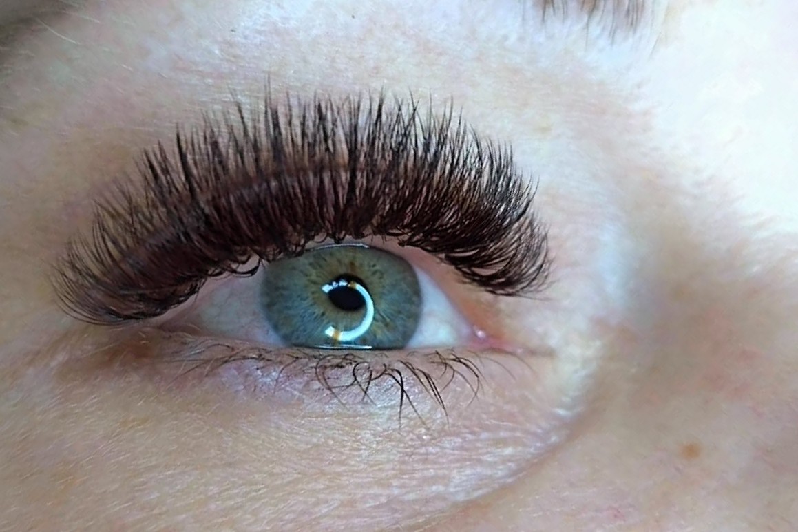Volle, donkere wimperextensions bij een klant met blauwe ogen